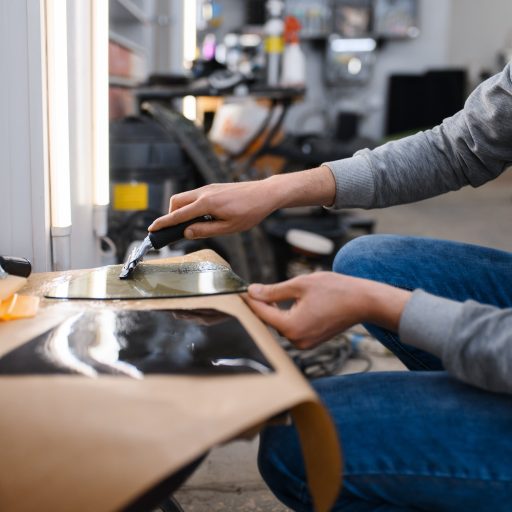 Male worker prepares sheet of car tinting